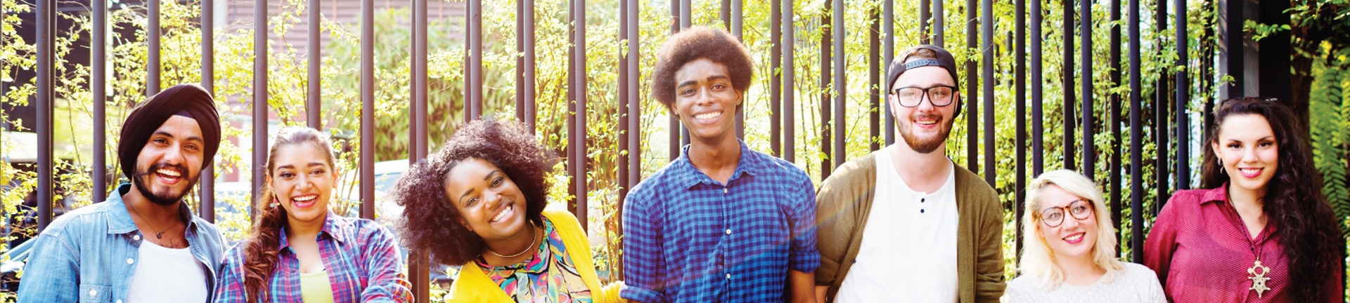 A line of people smiling in front of a forest